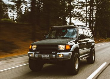 timelapse photography of green SUV on road